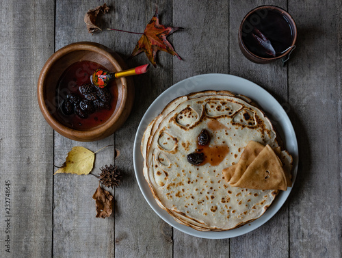 pancakes with jam and tea for breakfaston a wooden background photo