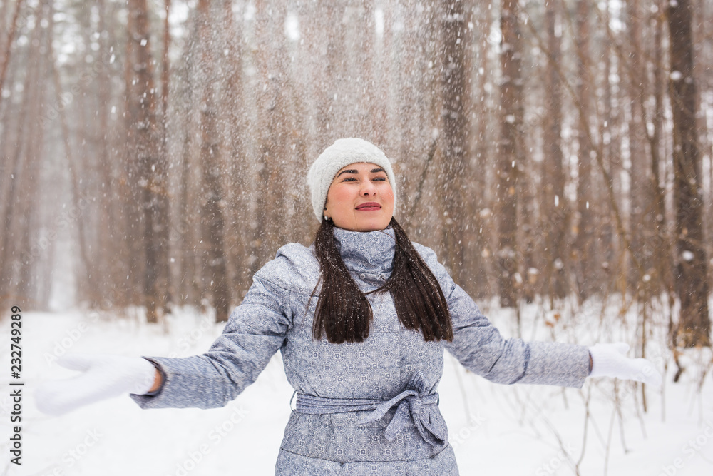 Obraz premium Young pretty woman throwing snow in the air in winter holidays