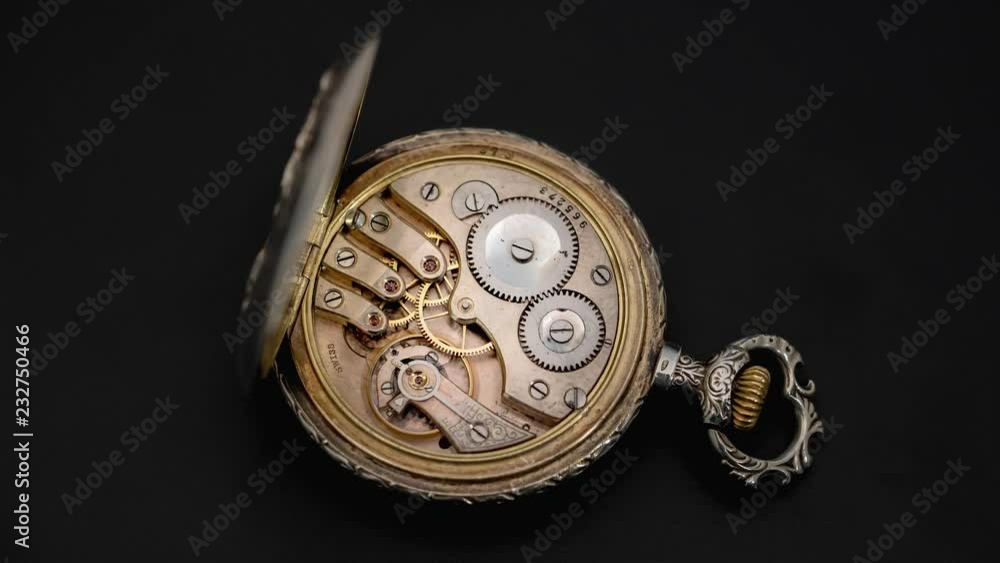 Rotating mechanism of the gears of an antique pocket watch. Close up. Time lapse . Back background Rotating mechanism of the gears of an antique pocket watch. Close up. Time lapse . Back background