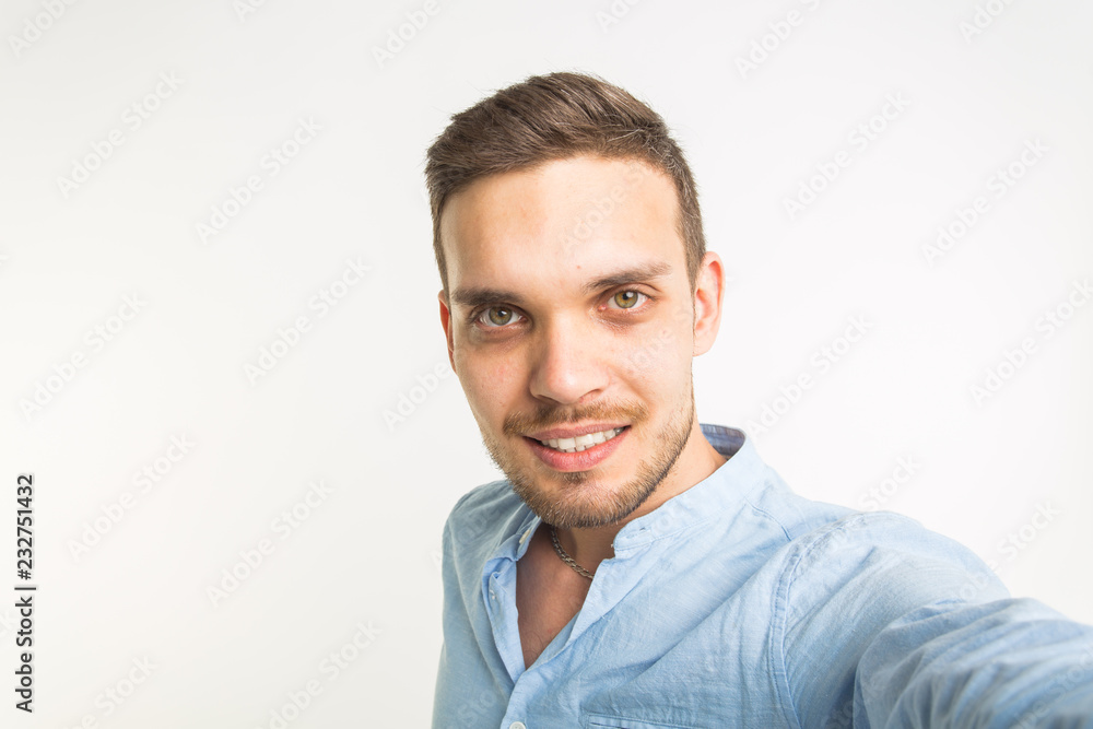 Close up portrait of a cheerful bearded man taking selfie over white background Close up portrait of a cheerful bearded man taking selfie over white background