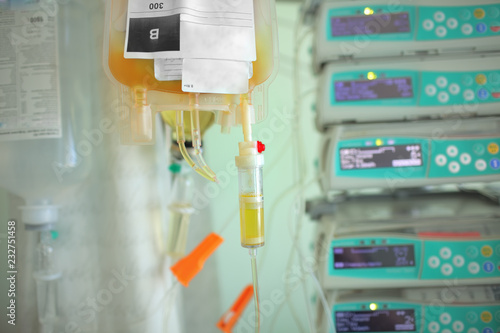 Blood plasma bag dripping to the patient on the background og medical equipment photo