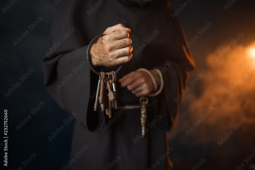 Medieval monk holds a bunch of keys in hands