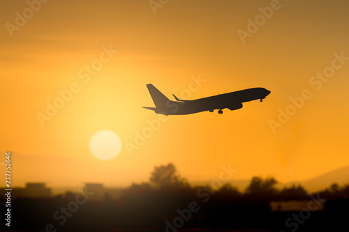 Silhouette airplane takeoff at sunset
