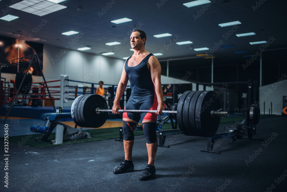 Powerlifter keeps the weight of heavy barbell Powerlifter keeps the weight of heavy barbell