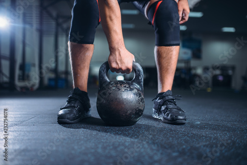 Male athlete prepares for exercise with kettlebell