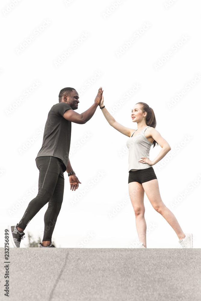 a pair of athletes do a warm-up. A loving couple an African American man and a European woman are sporting. Give Fife a pair of athletes do a warm-up. A loving couple an African American man and a European woman are sporting. Give Fife