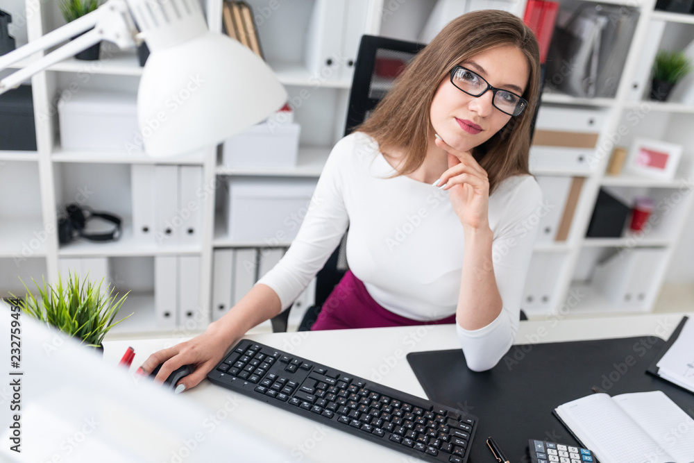 Portrait of a young girl at a computer Desk in the office. Portrait of a young girl at a computer Desk in the office.