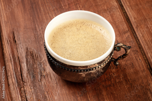 Coffee in a vintage cup on a dark rustic wooden background with copy space