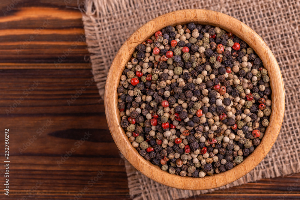Mix of peppers in bowl burlap napkin on wooden background Mix of peppers in bowl burlap napkin on wooden background