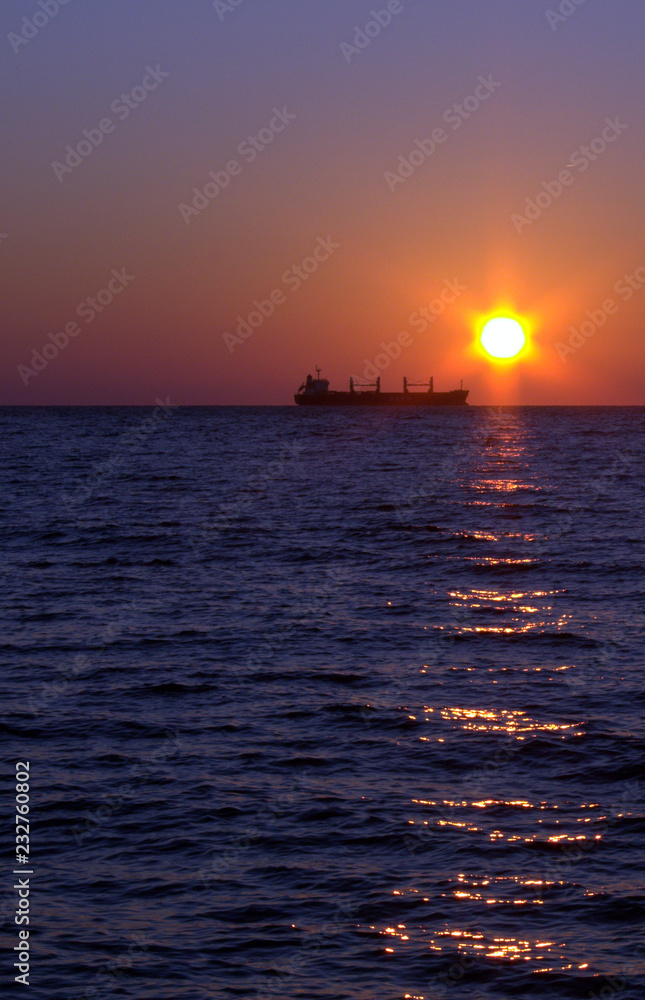 Cargo ship at sunset in the Black sea Cargo ship at sunset in the Black sea