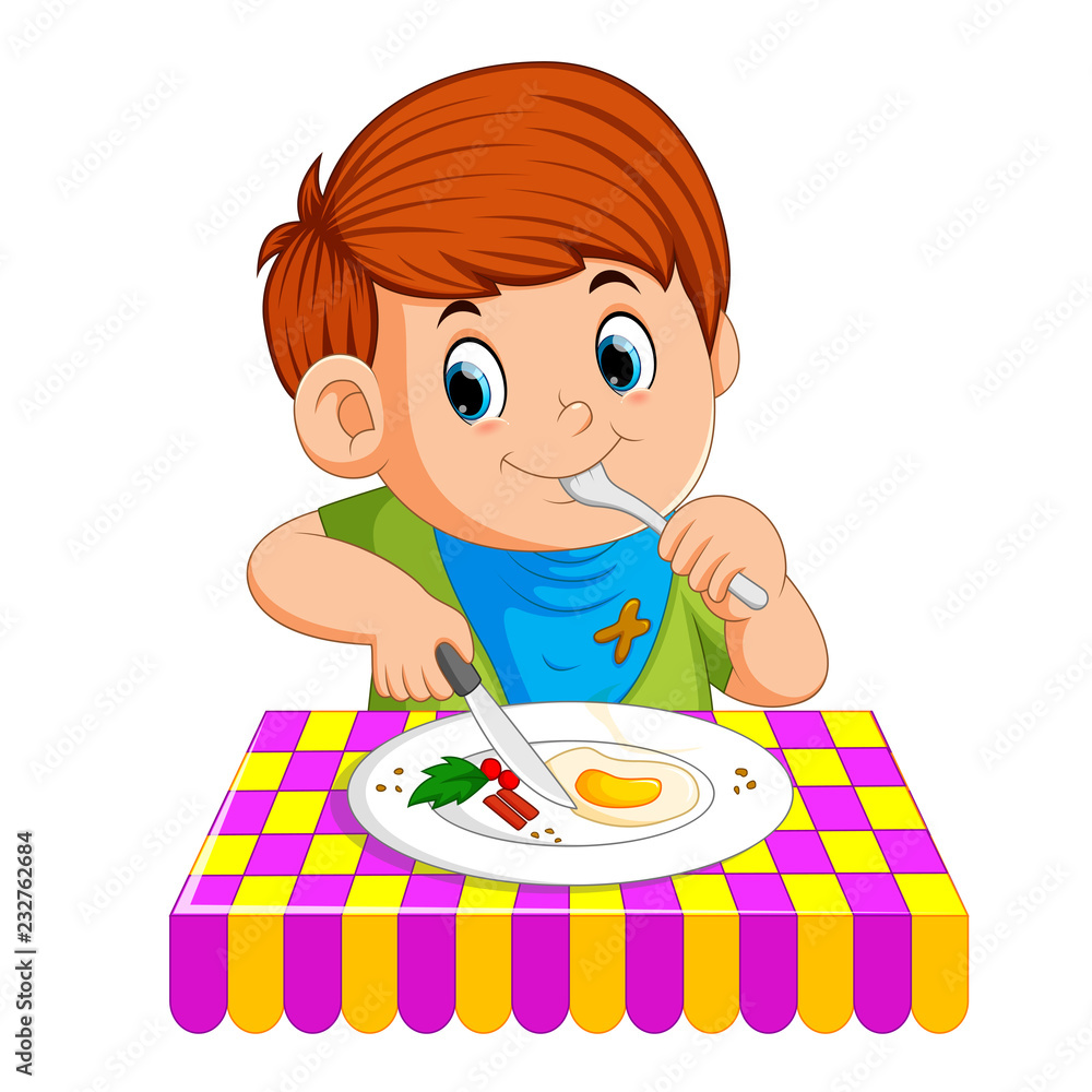 A young boy sitting while enjoy having breakfast A young boy sitting while enjoy having breakfast