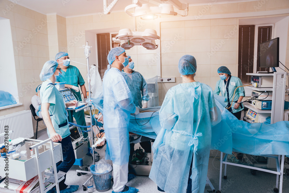 Process of gynecological surgery operation using laparoscopic equipment. Group of surgeons in operating room with surgery equipment Process of gynecological surgery operation using laparoscopic equipment. Group of surgeons in operating room with surgery equipment