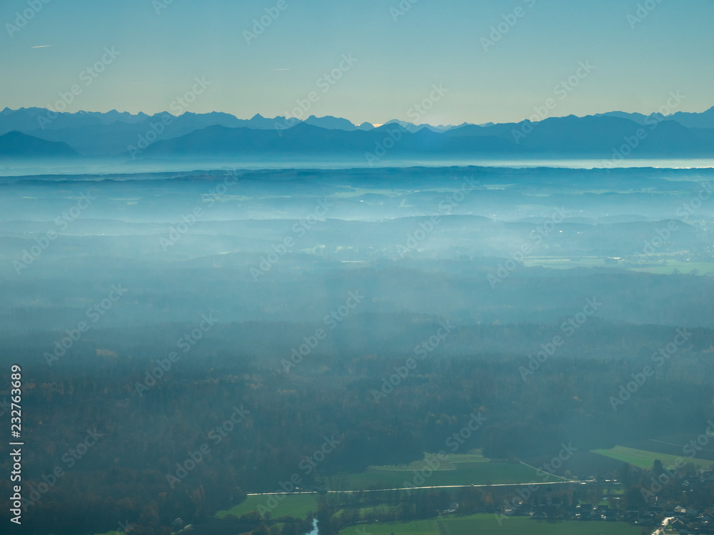 Helicopter view from top to Munich sourounding area during fog with alps at the background