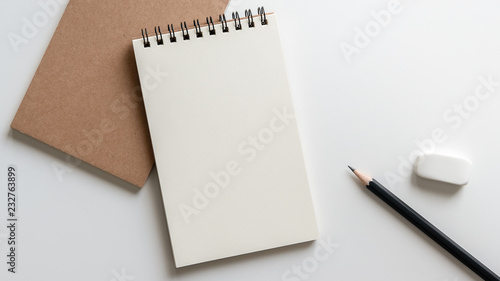 open blank spiral notebook with pencil and eraser on white background.Empty Space for your text. photo