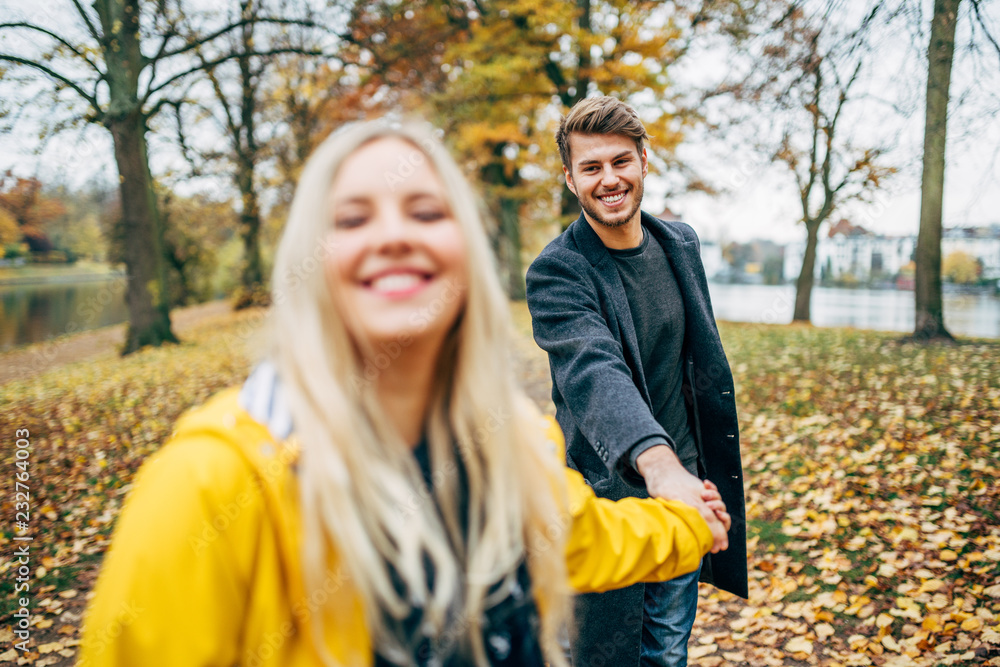  young couple having fun outdoors in autumn park, fall. Loughing and romp around