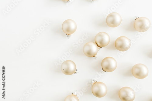 Christmas pattern with golden decoration balls on white background. Flat lay, top view.