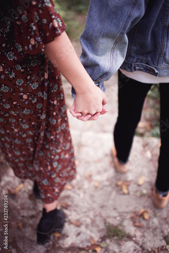 Teenage boy and girl with holding hands walking outdoors. Relationship. Love concept.