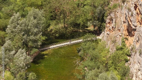 Tourists crossing a brigde in the gardens of Monasterio de Piedra in Aragon, Spain -view from above photo