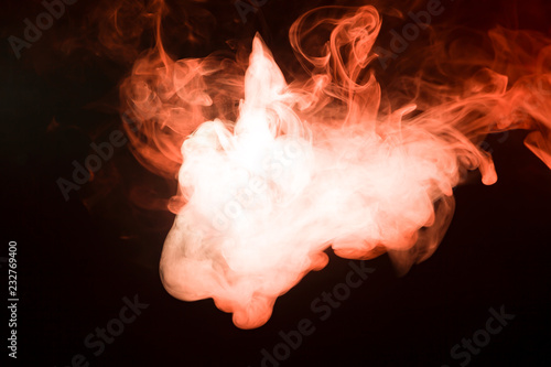 Multicolored smoke from a wap of red and white color of the strange mystical form on on a black isolated background. Bright clouds in the form of the animal's head. photo