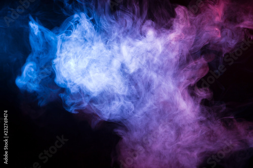 Multicolored smoke from a vape of blue and purple color of the strange mystical form on on a black isolated background. Bright clouds in the abstract form.