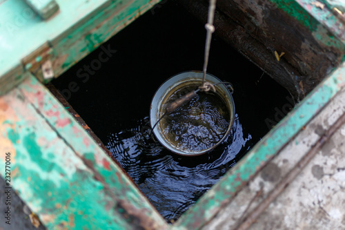 Bucket of water is getting out of the well. View from above