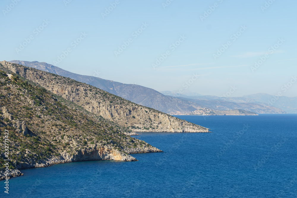 Summer time in Greece. Beautiful Greek coastline next to sea shore during warm weather.