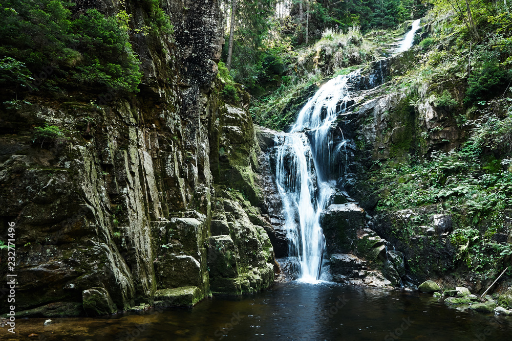 Forest waterfall. Water flowing from the stone mountain. Forest waterfall. Water flowing from the stone mountain.