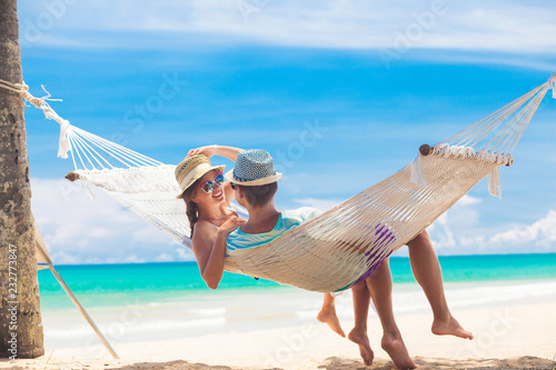 Young couple in love relaxing in a hammock by the beach
