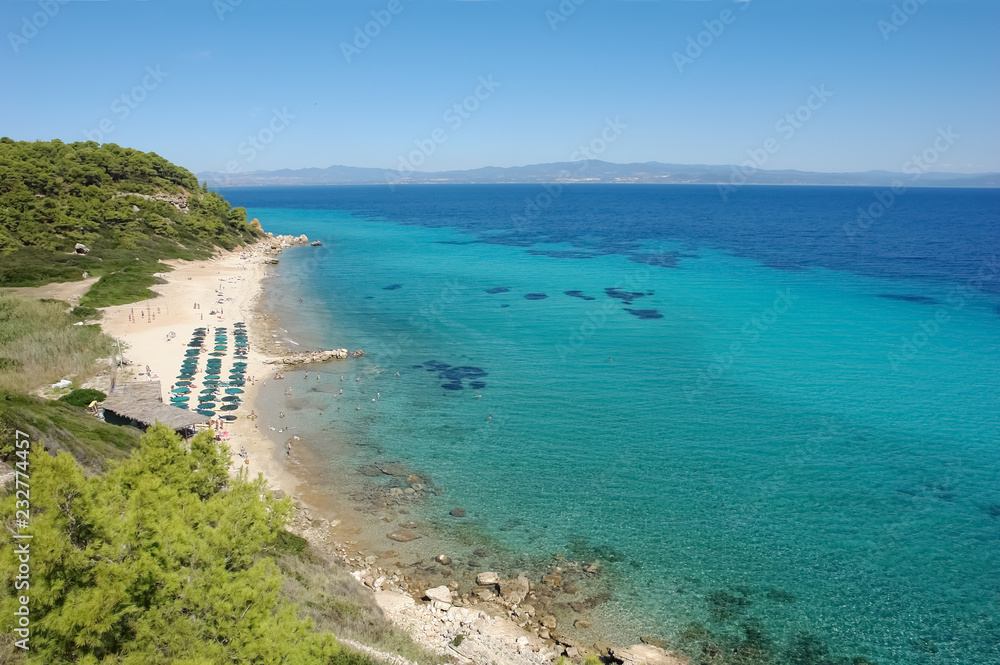 View on the sandy beach and crystal clear turquoise sea in Greece.