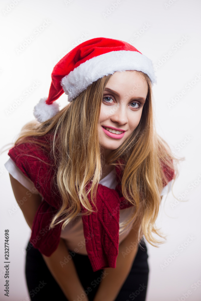 Beautiful smiling woman wear santa claus hat and leaned toward the camera to say something Beautiful smiling woman wear santa claus hat and leaned toward the camera to say something