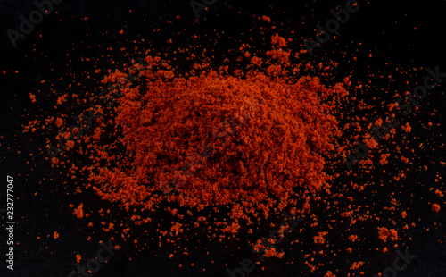 Pile of red paprika powder black background