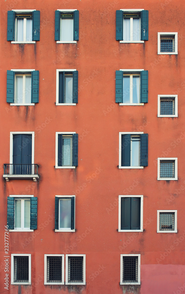 Fototapeta premium Many windows. Medieval facade. Window shutters. Architectural style of Italy. Facade with many doors and windows