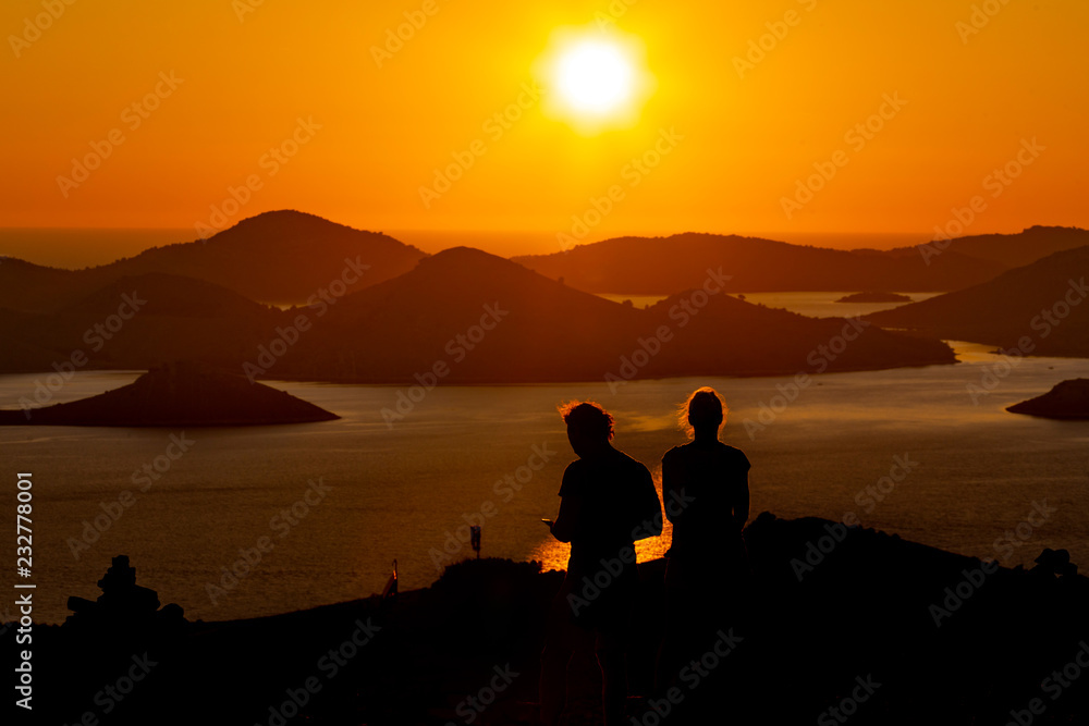 silhouettes of a couple at the romantic sunset on the island