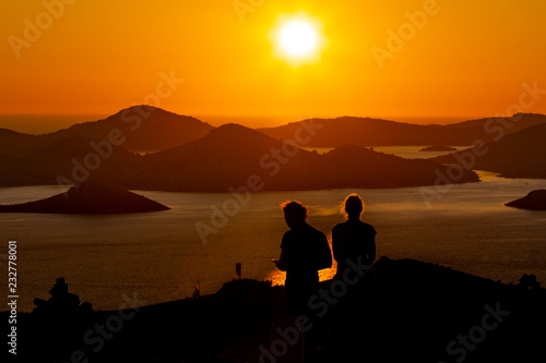silhouettes of a couple at the romantic sunset on the island