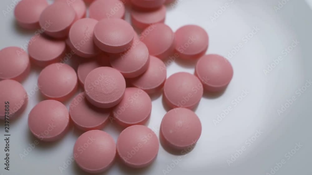 Pink pills rotate on a white background. Pink pills rotate on a white background.