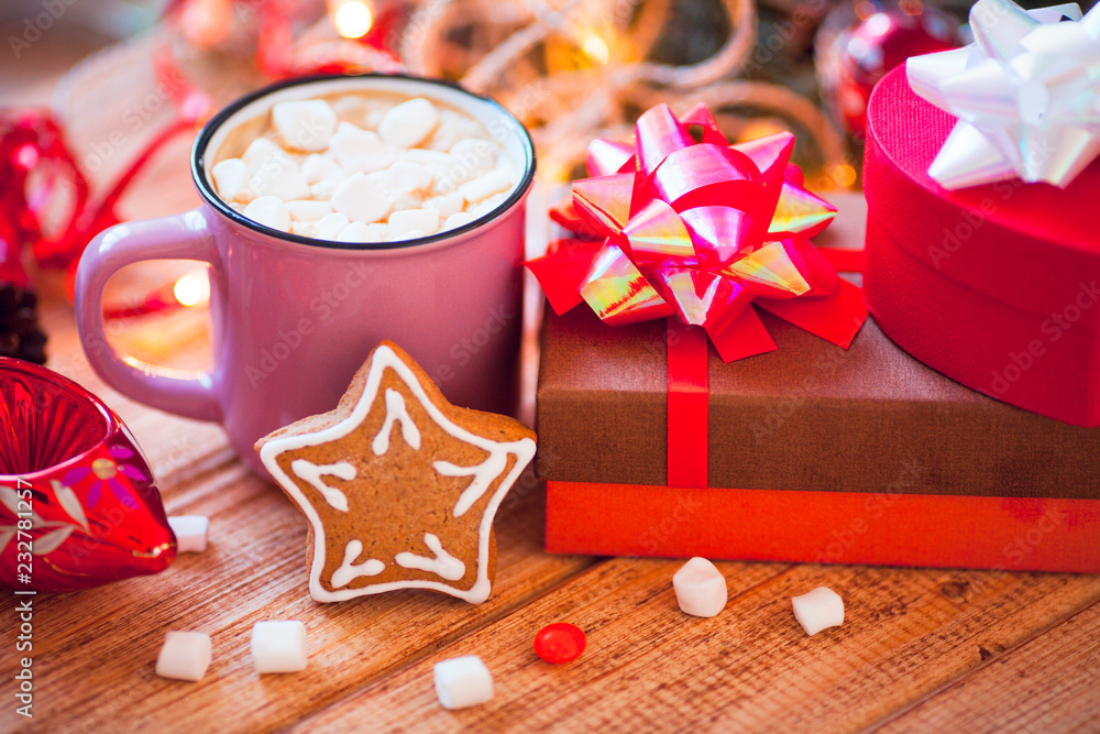 Cup of chocolate with marshmallow, gingerbread cookies, gifts and beautiful Christmas decorations with lights on the wooden background. Flat lay, top view, close up space for a text. Cup of chocolate with marshmallow, gingerbread cookies, gifts and beautiful Christmas decorations with lights on the wooden background. Flat lay, top view, close up space for a text.