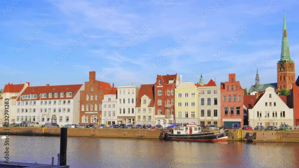View on Trave river and Lubeck city embankment at sunny day. View on Trave river and Lubeck city embankment at sunny day.