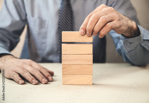 Man stacking wooden blocks. Development concept