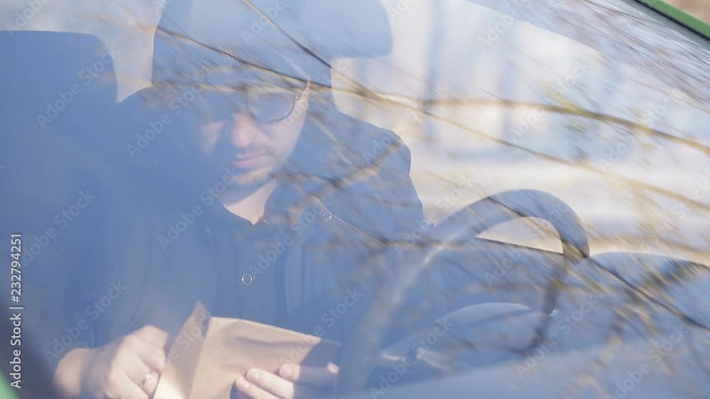 Private detective man sitting inside car and photographing with dslr camera Private detective man sitting inside car and photographing with dslr camera
