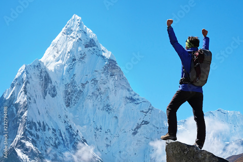 Hiker with backpacks reaches the summit of mountain peak. Success freedom and happiness achievement in mountains. Active sport concept. © Andrii Vergeles