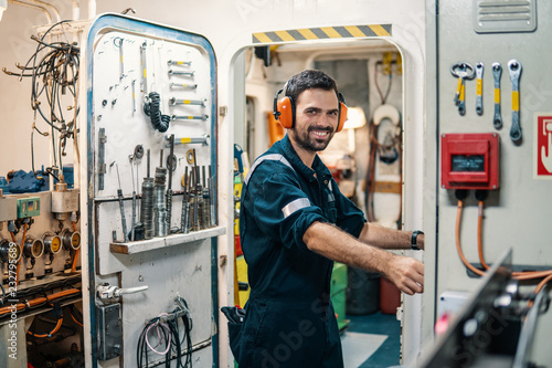Marine engineer officer in engine control room ECR. Seamen's work. He starts or stops main engine of ship