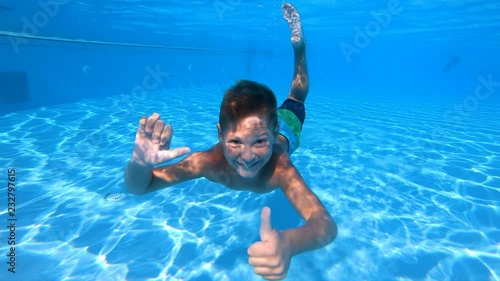 Cute boy swimming underwater in slow motion