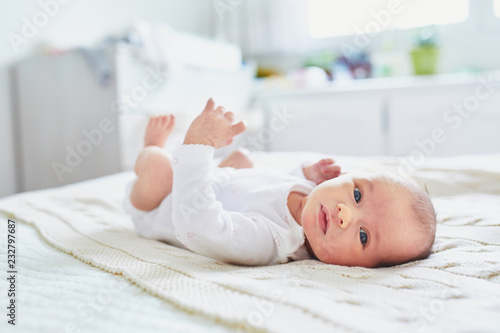 Baby girl lying on bed in nursery