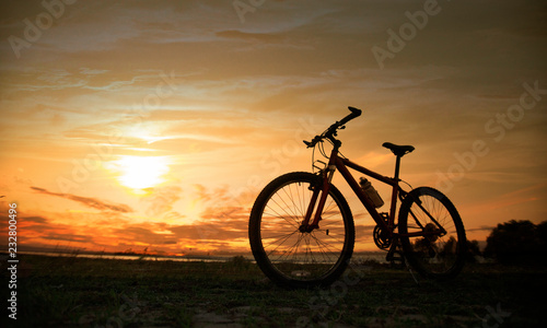 Silhouette bicycle with sunset or sunrise background © ittipol