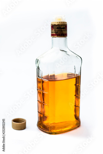 Scotch or whisky or whiskey bottle isolated on white with half filled in it,Close up view along with top shot.