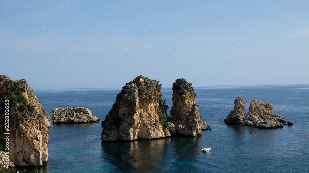 Scopello, Province of Trapani, Sicily. This is small bay containing an old tonnara (tuna fish processing plant). In front of it rises the faraglioni (sea stacks). Scopello, Province of Trapani, Sicily. This is small bay containing an old tonnara (tuna fish processing plant). In front of it rises the faraglioni (sea stacks).
