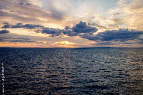 Travel by ferry in the Baltic Sea at sunrise with Sweden on the horizon. Taken from the Color Line Fantasy which is a cruise ferry between Kiel and Oslo. 
