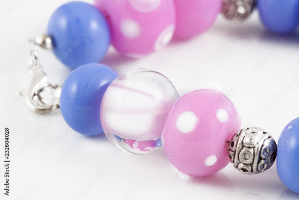 Collection of colorful glass beads, bracelets, pendant of different sizes and shapes. Colored Venetian, Murano glass, Silver glass, millefiori. Shot on a white background. Collection of colorful glass beads, bracelets, pendant of different sizes and shapes. Colored Venetian, Murano glass, Silver glass, millefiori. Shot on a white background.