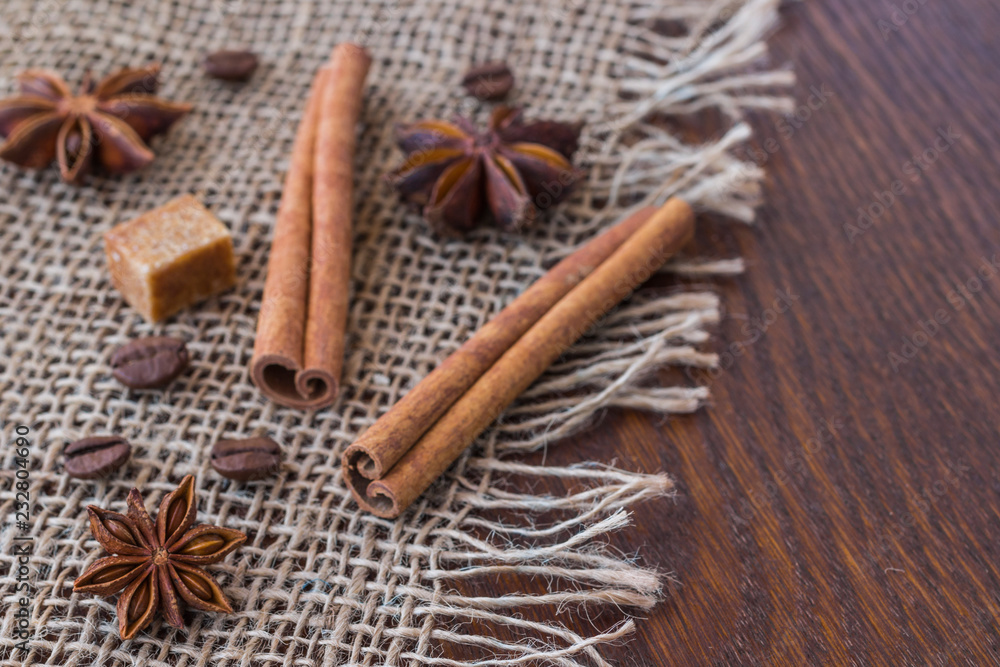 Star anise, cinnamon sticks, sugar cube and coffee grains on sackcloth Star anise, cinnamon sticks, sugar cube and coffee grains on sackcloth