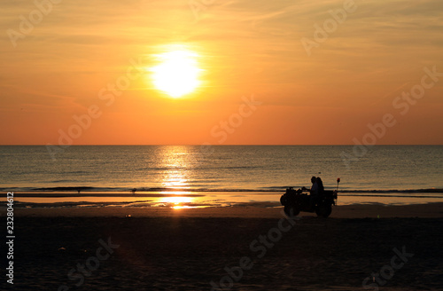 Golden sunset and people on the North Sea beach in Bloemendaal, The Netherlands.